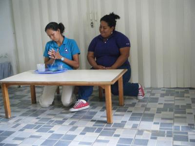 Cándida receiving training from one of the Costan Rican teachers on how to use materials correctly